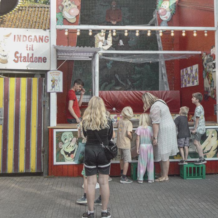 Children playing a game at a funfair stall